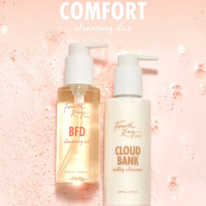 Fourth Ray Beauty Cloud Bank Milky Cleanser (5.8 fl oz) pump bottle stands beside BFD Cleansing Oil (4.15 fl oz) on a pink, foamy backdrop, showcasing a comforting cleansing duo; gentle ColourPop Face Cleanser for daily use.